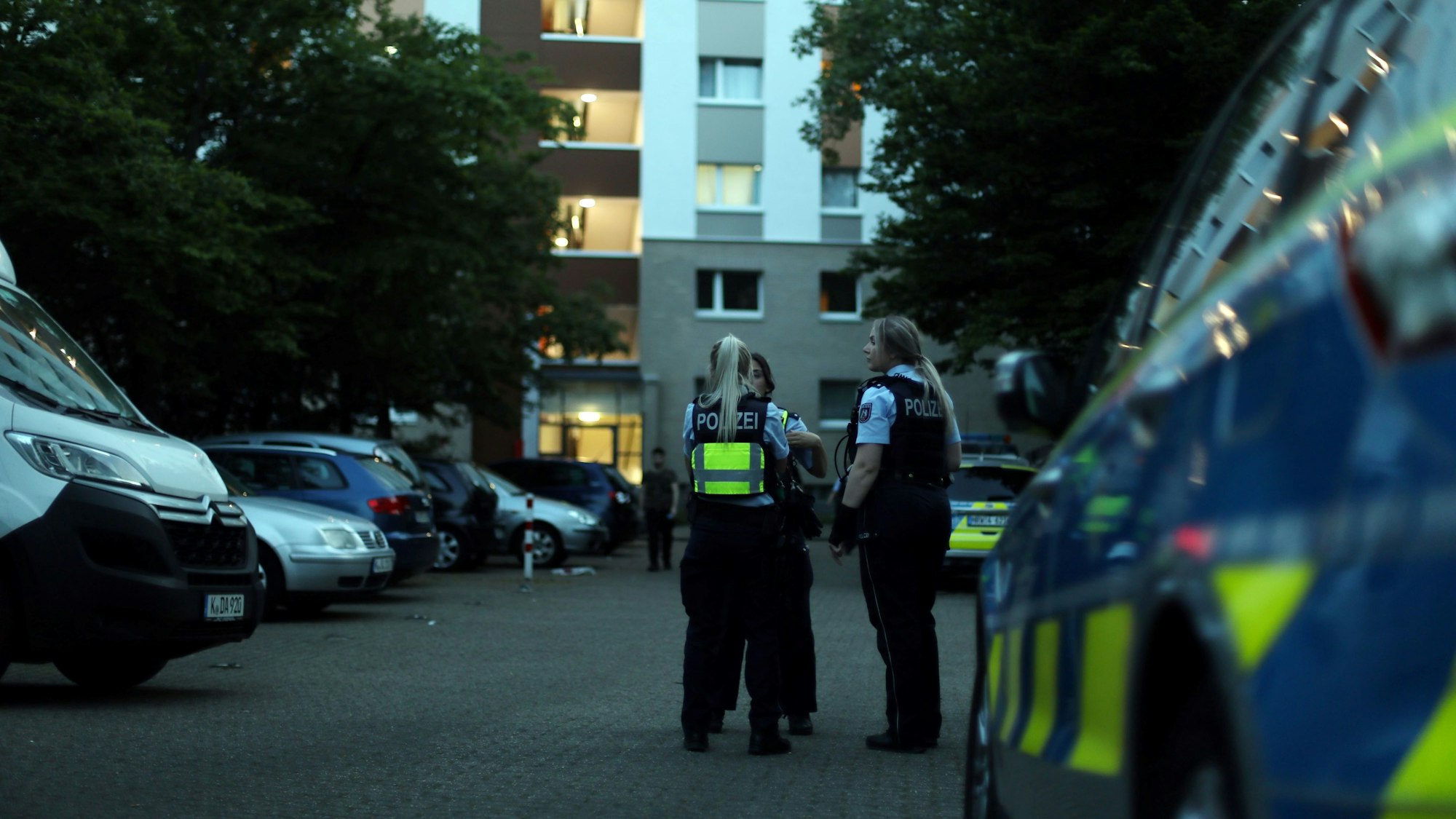 Beamte der Polizei Köln bei Ermittlungen vor ihrem Dienstwagen