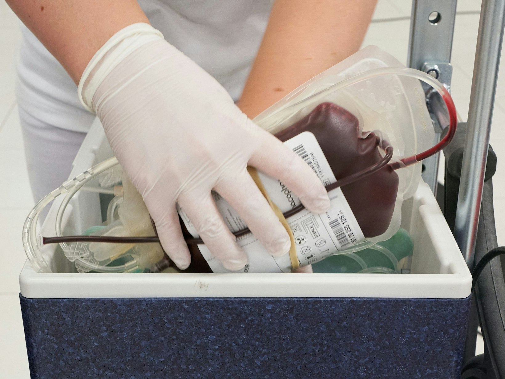 Ein Mitarbeiter des DRK-Blutspendedienstes verstaut eine Blutkonserve in einem Kühlbehälter.