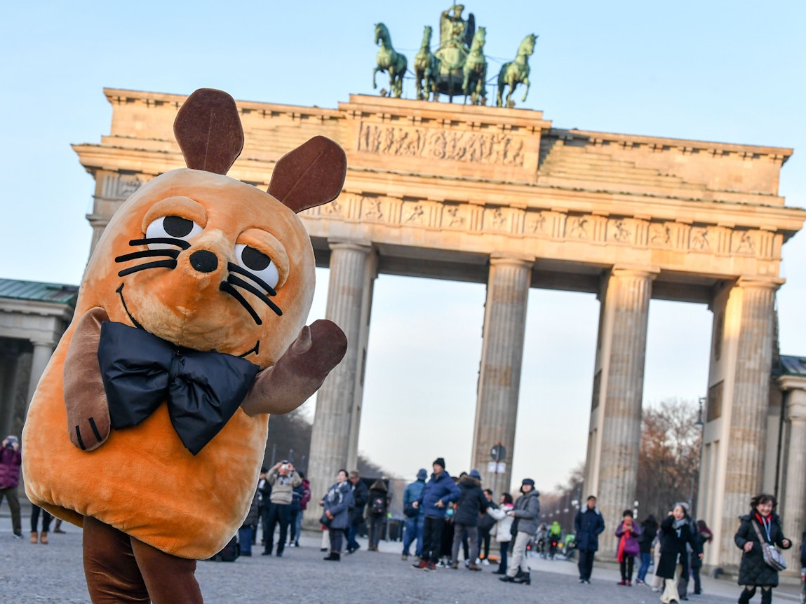 Die „Maus“ aus der ARD-Serie „Die Sendung mit der Maus“ steht vor dem Brandenburger Tor in Berlin.