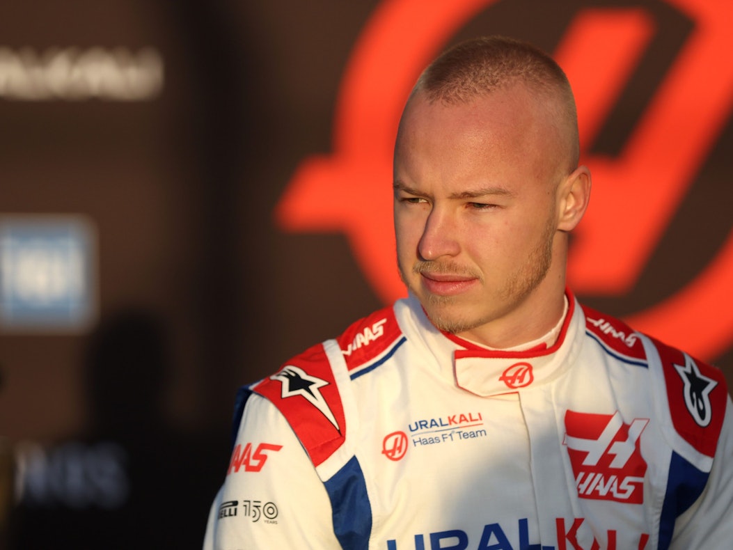 Nikita Mazepin steht im Rennanzug an der Strecke in Barcelona.