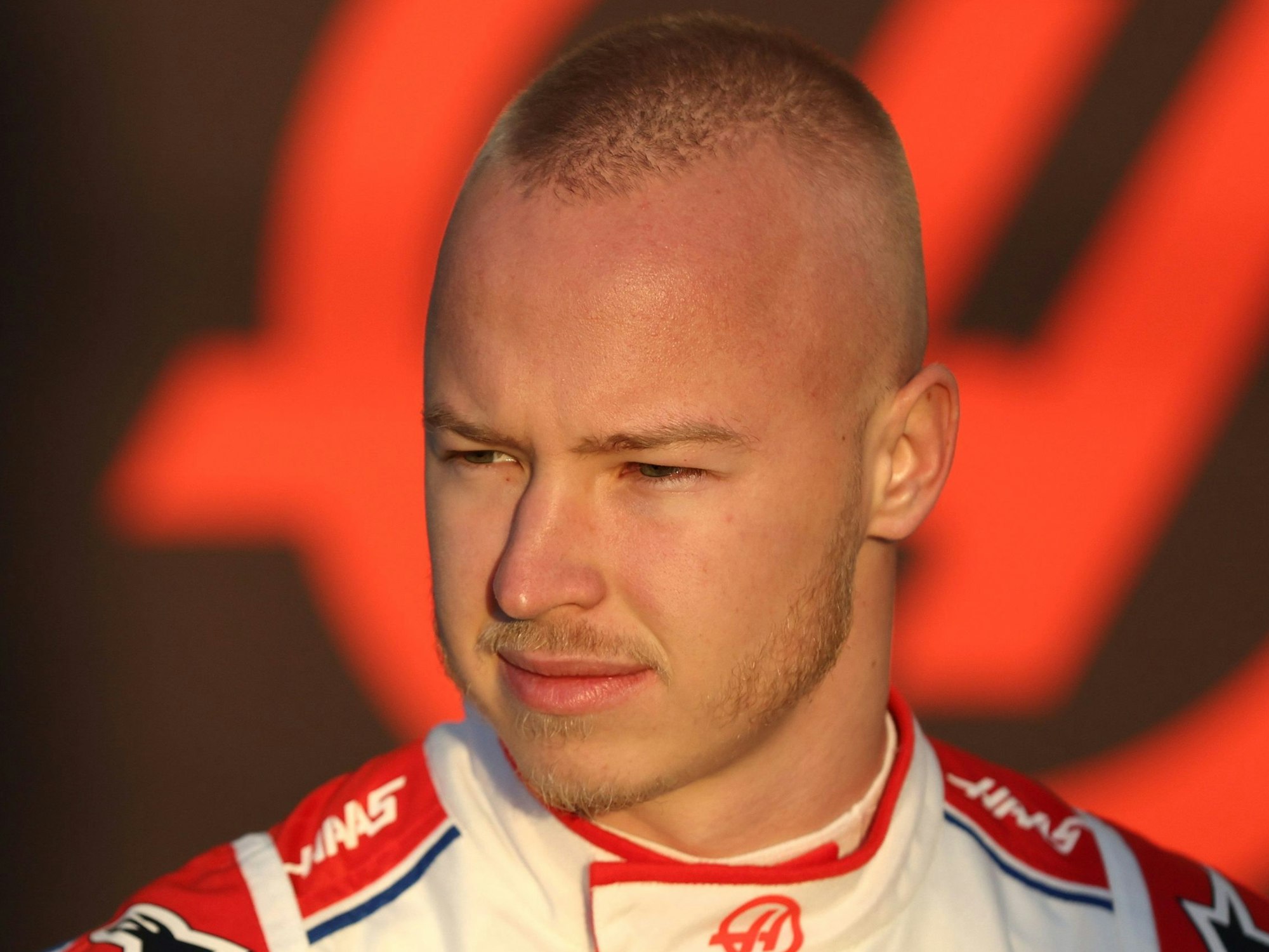 Nikita Mazepin steht im Rennanzug an der Strecke in Barcelona.