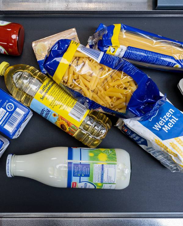 Lebensmittel, darunter Sonnenblumenöl und Getreideprodukte, liegen in einem Supermarkt an der Kasse auf dem Band.