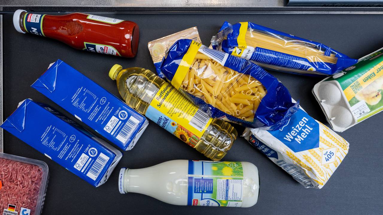 Lebensmittel, darunter Sonnenblumenöl und Getreideprodukte, liegen in einem Supermarkt an der Kasse auf dem Band.