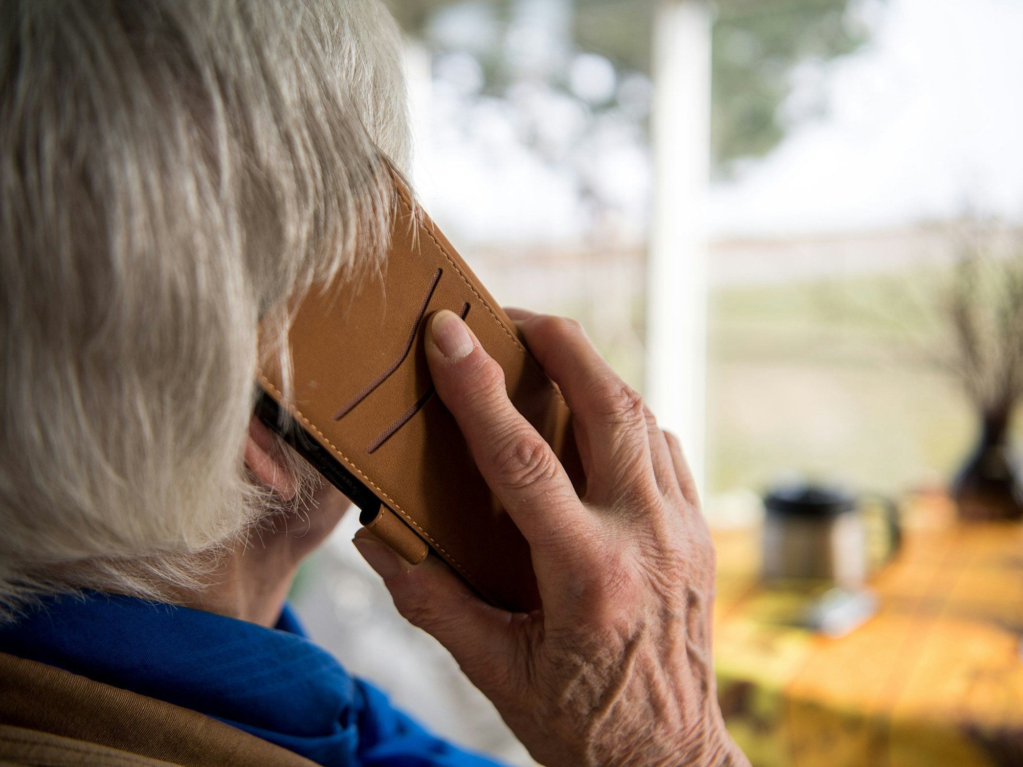 Eine ältere Dame telefoniert mit einem Smartphone.