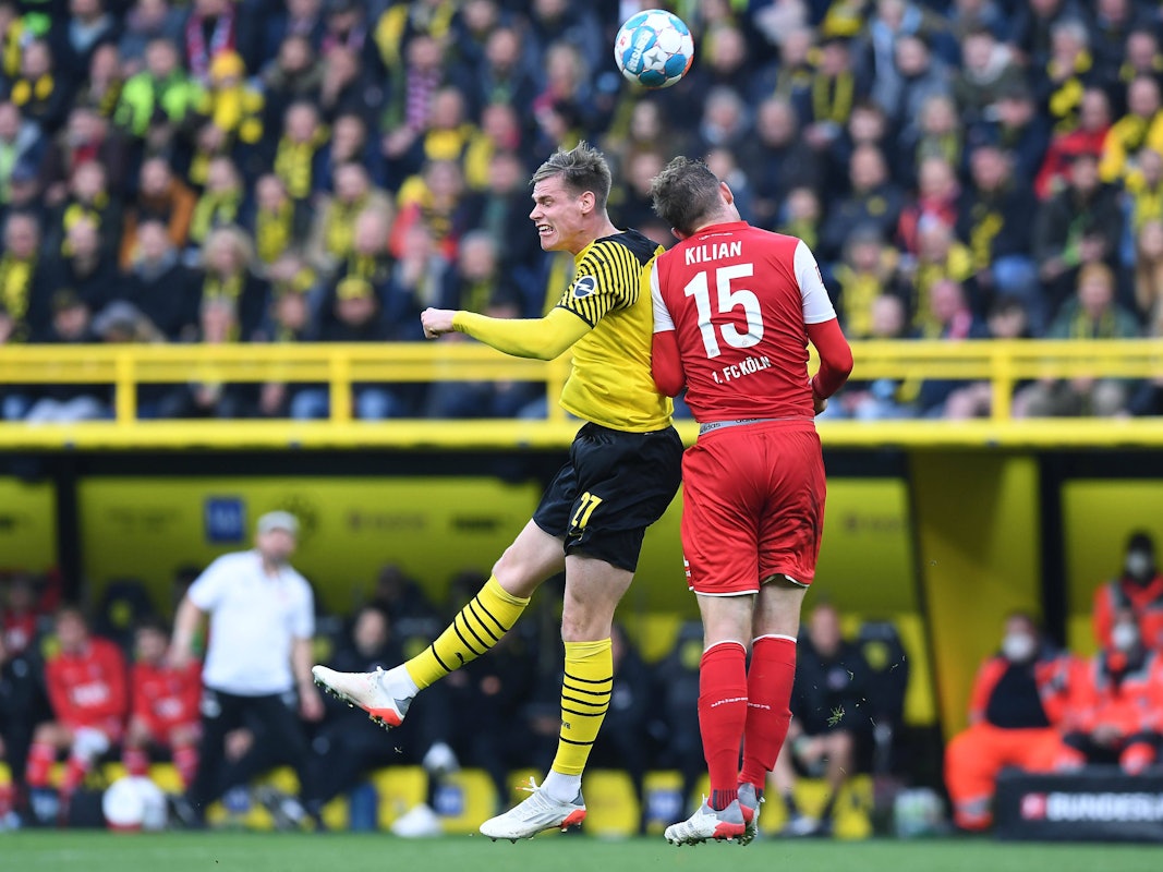 Steffen Tigges im Kopfballduell mit Luca Kilian beim Bundesliga-Duell zwischen Borussia Dortmund und dem 1. FC Köln.