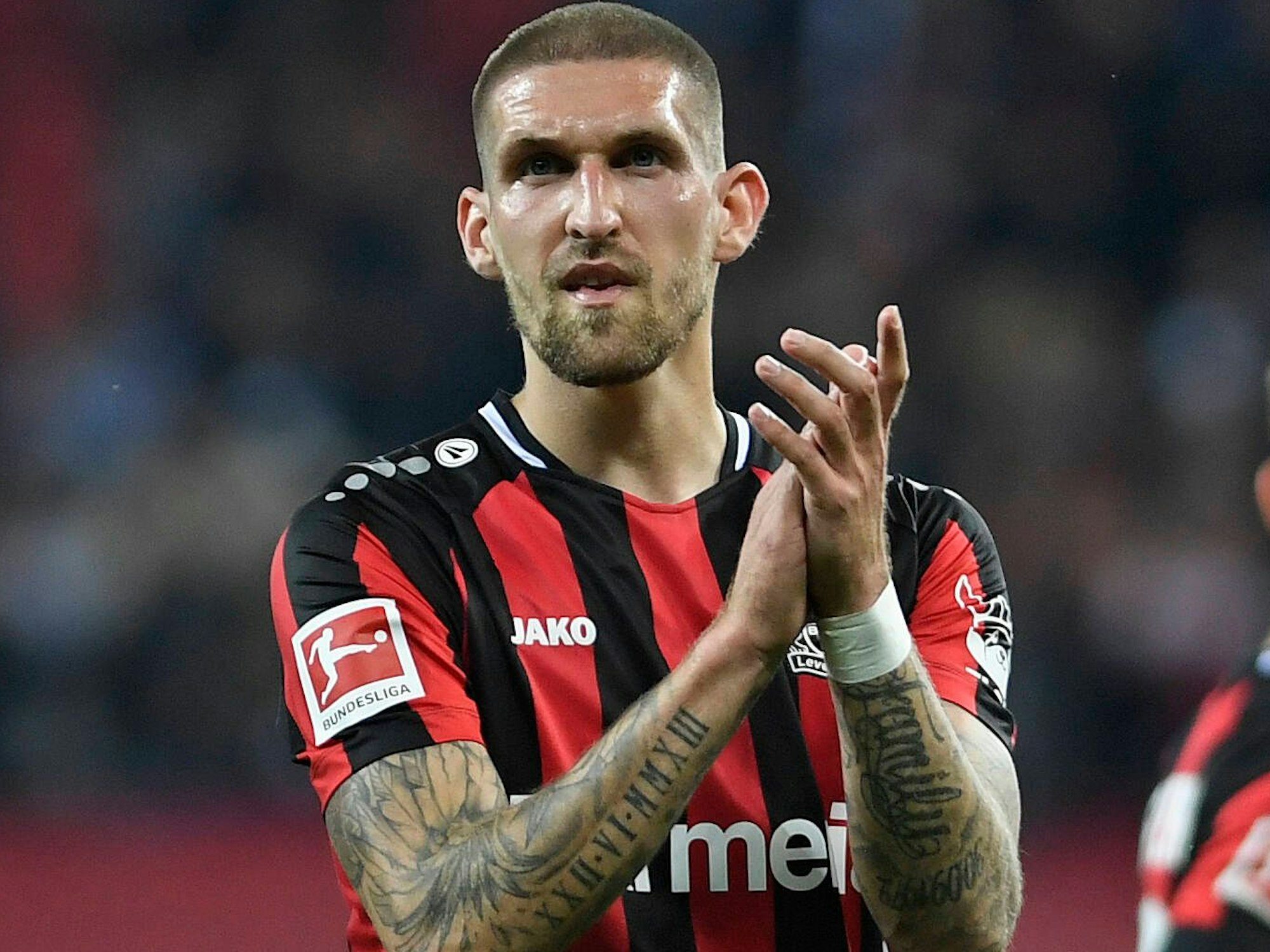 Bayer-Profi Robert Andrich bedankt sich klatschend bei den Fans.