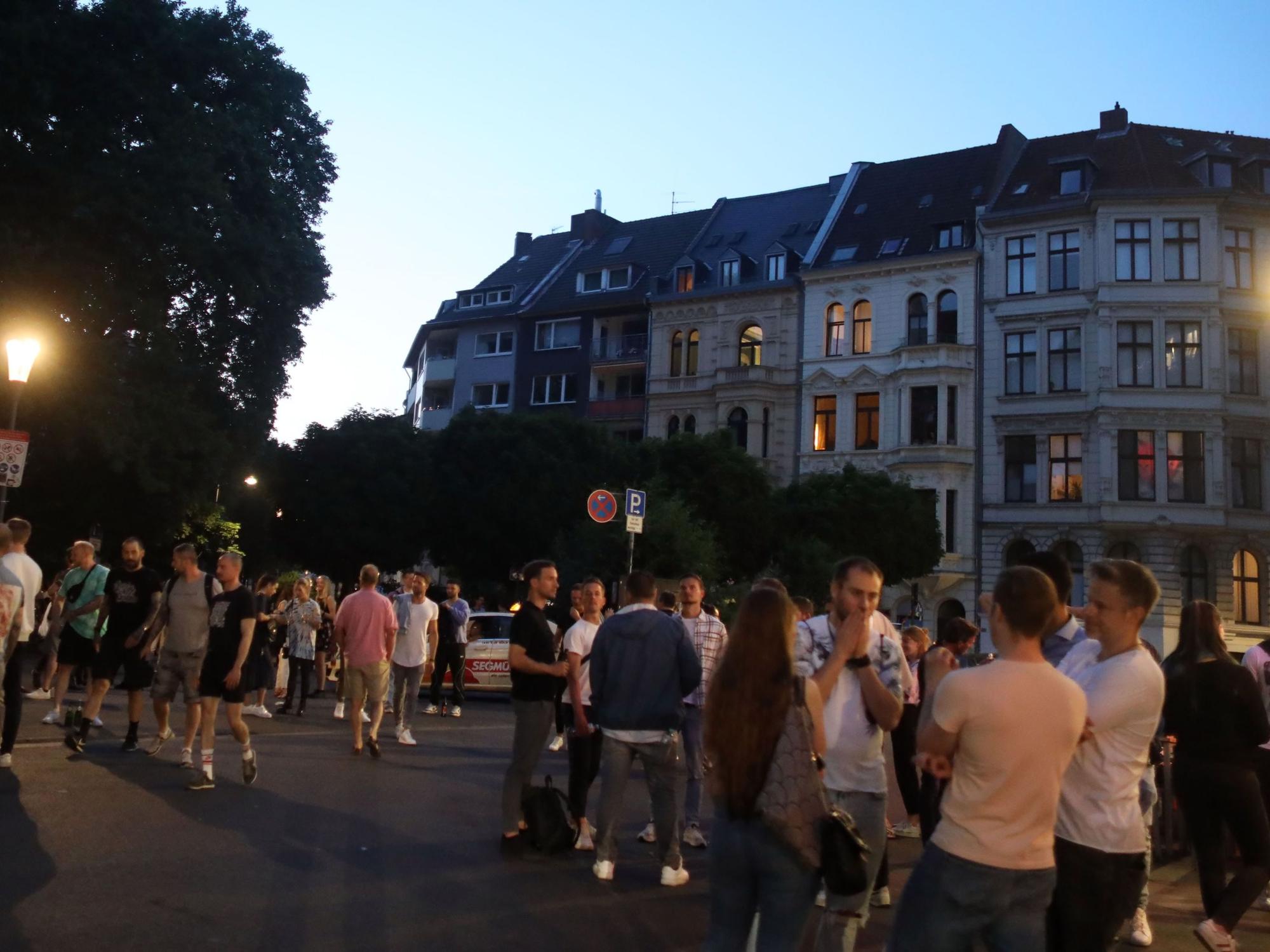 Menschen stehen auf einem Platz.