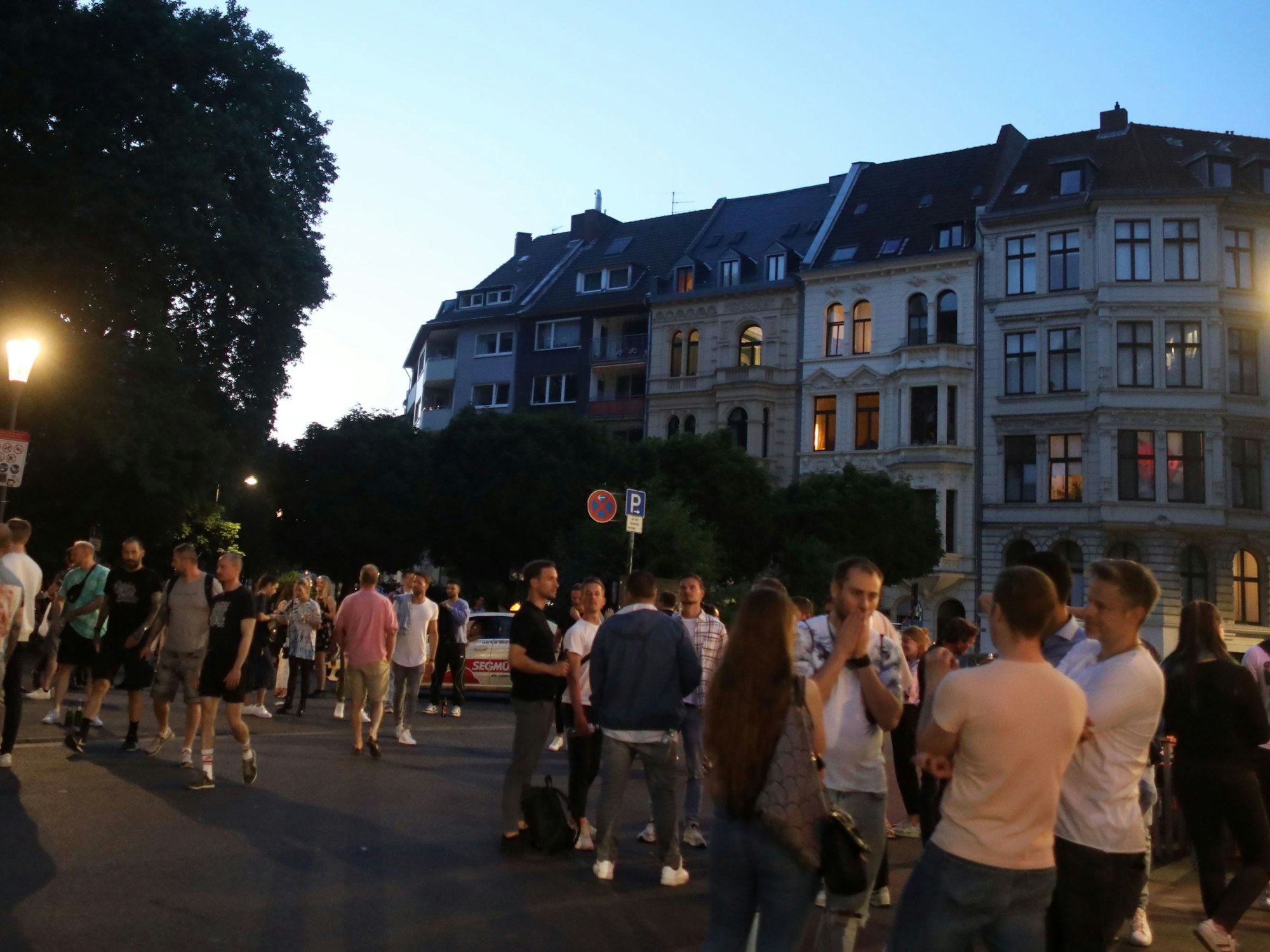 Menschen stehen auf einem Platz.