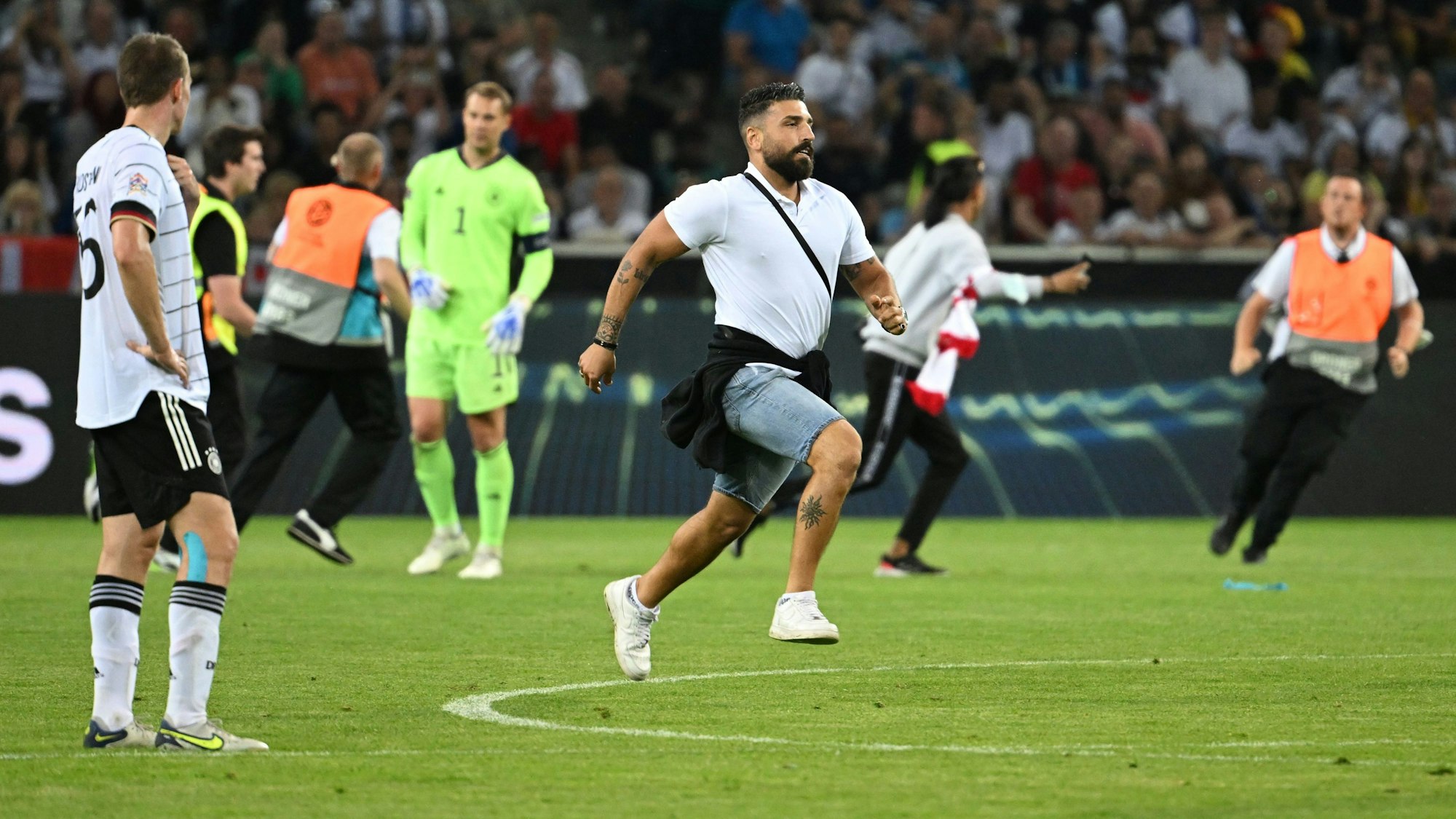 Ein Flitzer rennt beim Länderspiel über den Platz.