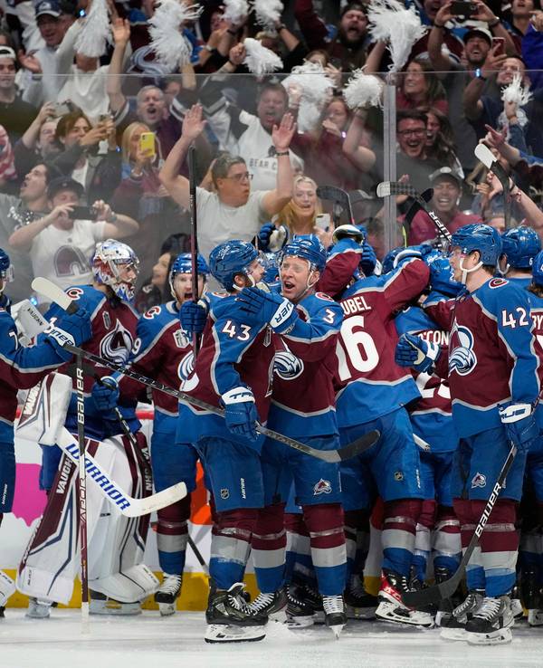Die Spieler der Colorado Avalanche stehen auf dem Eis und liegen sich in der Armen.