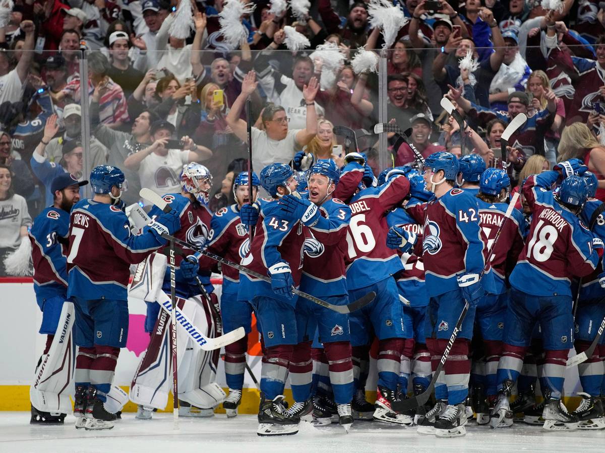 Die Spieler der Colorado Avalanche stehen auf dem Eis und liegen sich in der Armen.