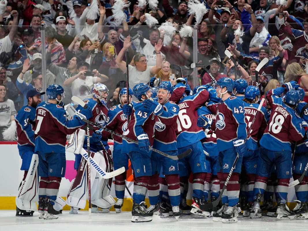 Die Spieler der Colorado Avalanche stehen auf dem Eis und liegen sich in der Armen.