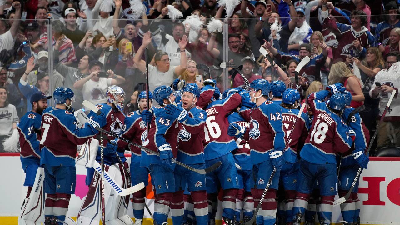 Die Spieler der Colorado Avalanche stehen auf dem Eis und liegen sich in der Armen.