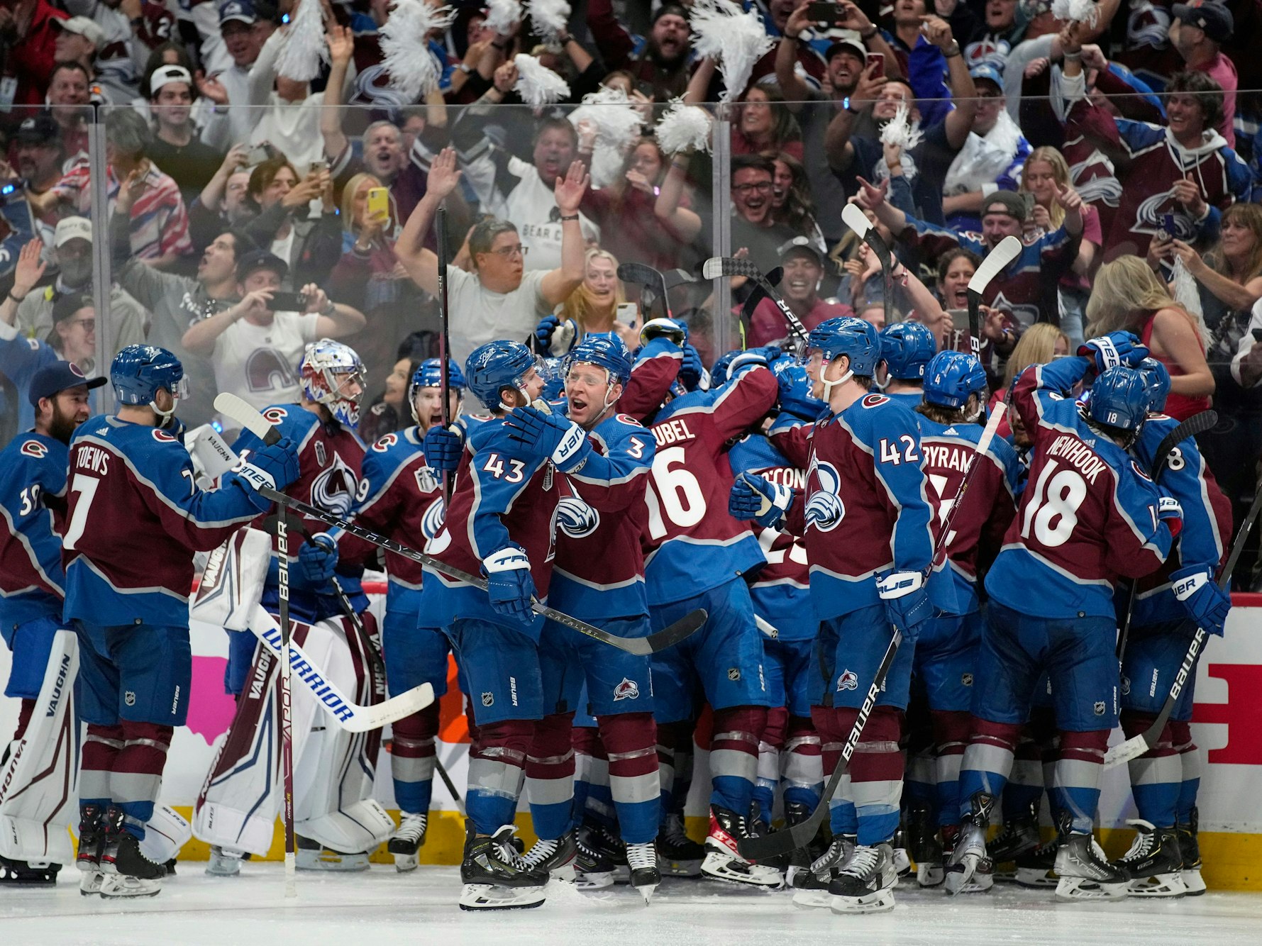 Die Spieler der Colorado Avalanche stehen auf dem Eis und liegen sich in der Armen.
