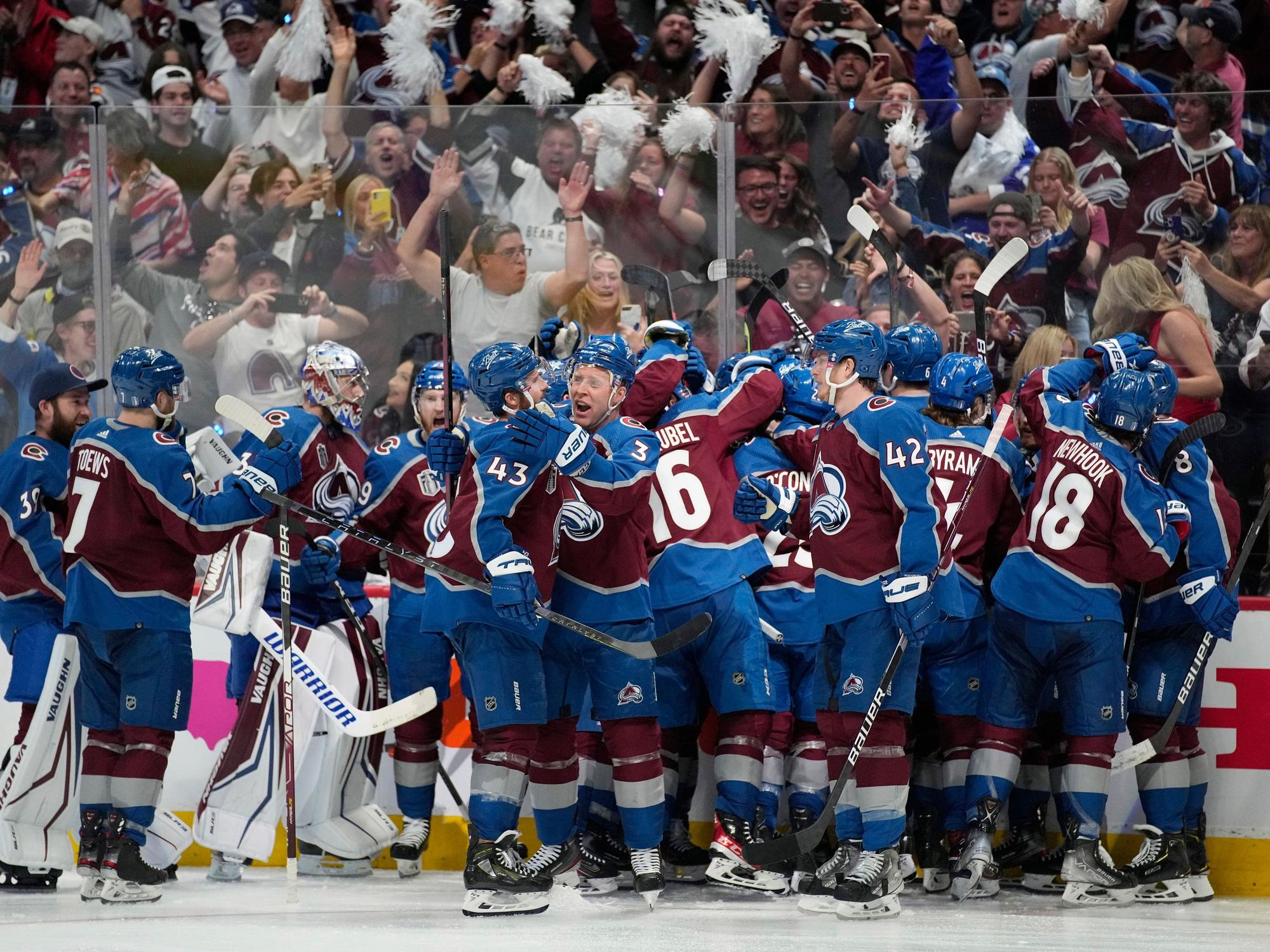 Die Spieler der Colorado Avalanche stehen auf dem Eis und liegen sich in der Armen.