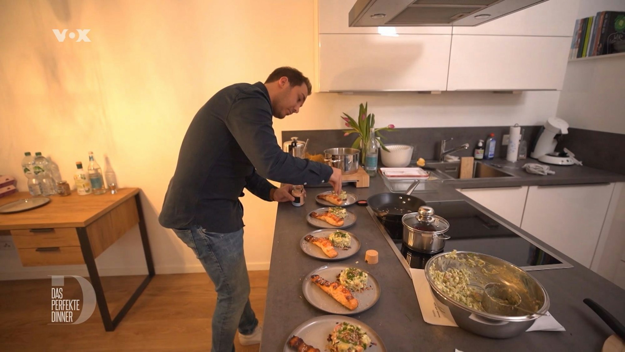 Domenik richtet die Vorspeisenteller mit gegrilltem Lachs und Acocado-Creme an.