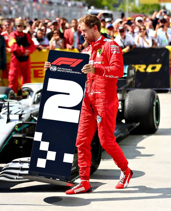 Sebastian Vettel tauscht nach dem Kanada-GP am 9. Juni 2019 die Positions-Schilder vor seinem und Lewis Hamiltons Auto.