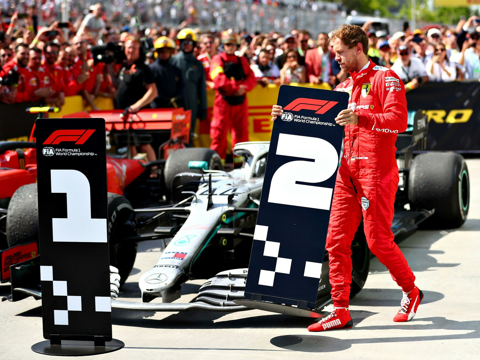 Sebastian Vettel tauscht nach dem Kanada-GP am 9. Juni 2019 die Positions-Schilder vor seinem und Lewis Hamiltons Auto.