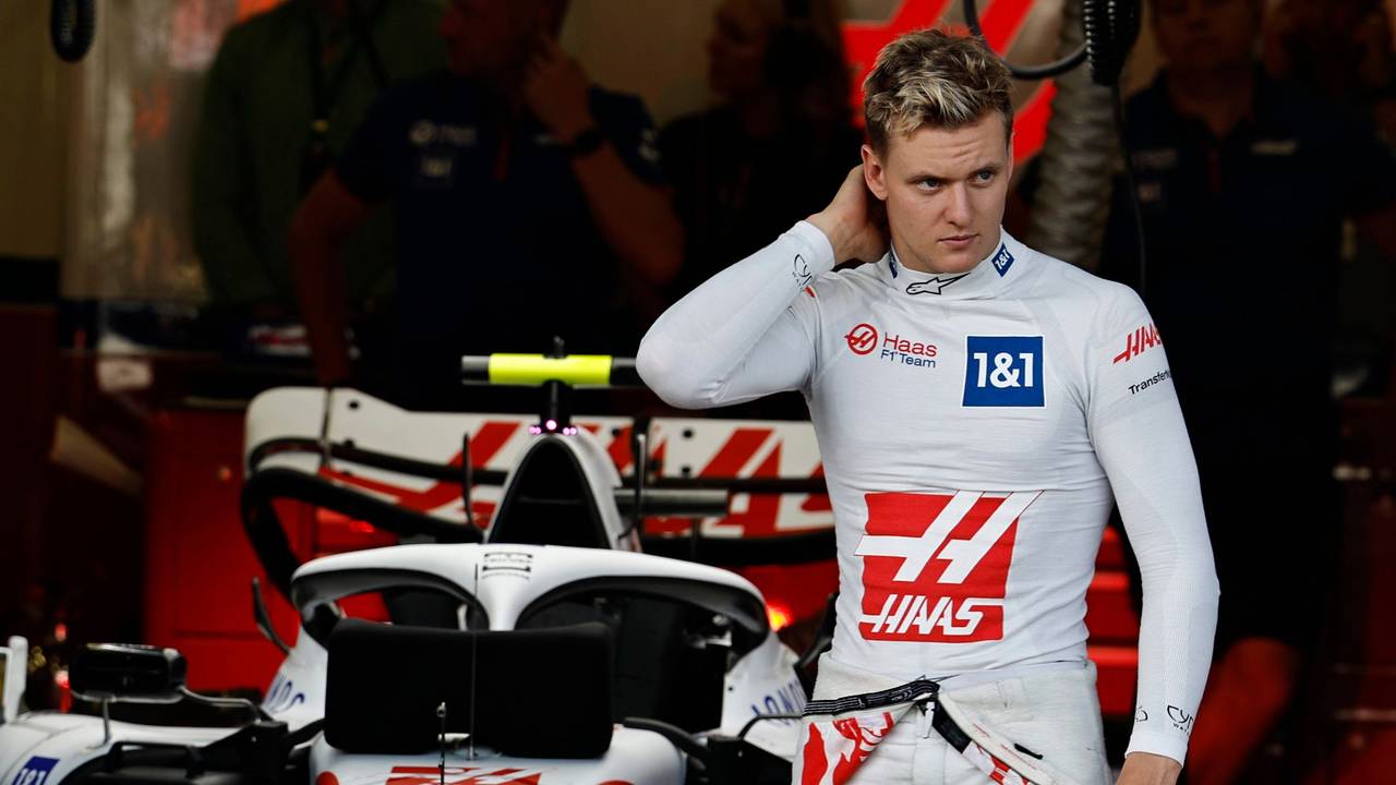 Mick Schumacher steht vor seinem Auto und fasst sich in den Nacken.