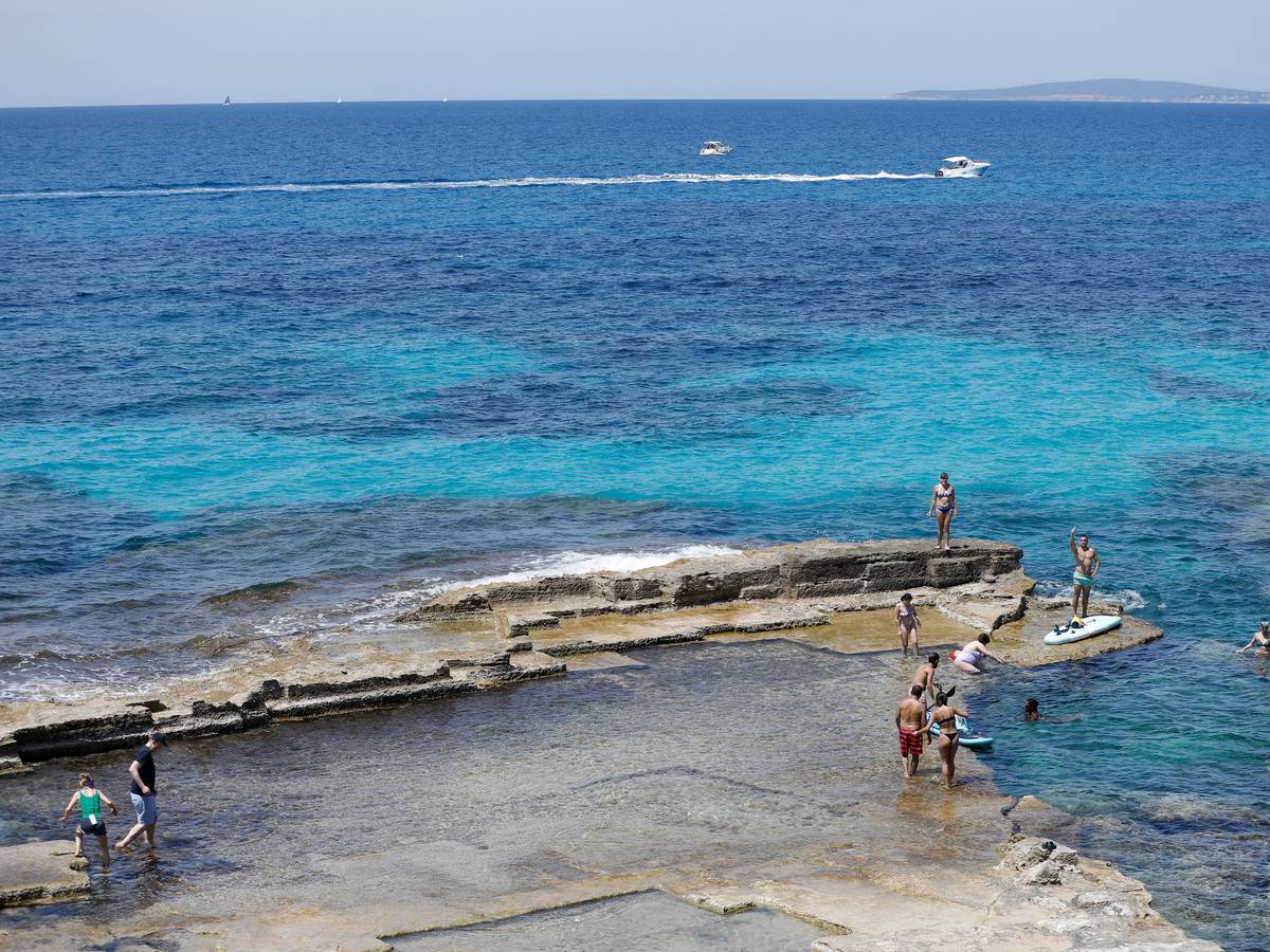 Menschen entspannen sich am Felsenstrand von Maioris an der Südostküste Mallorcas.