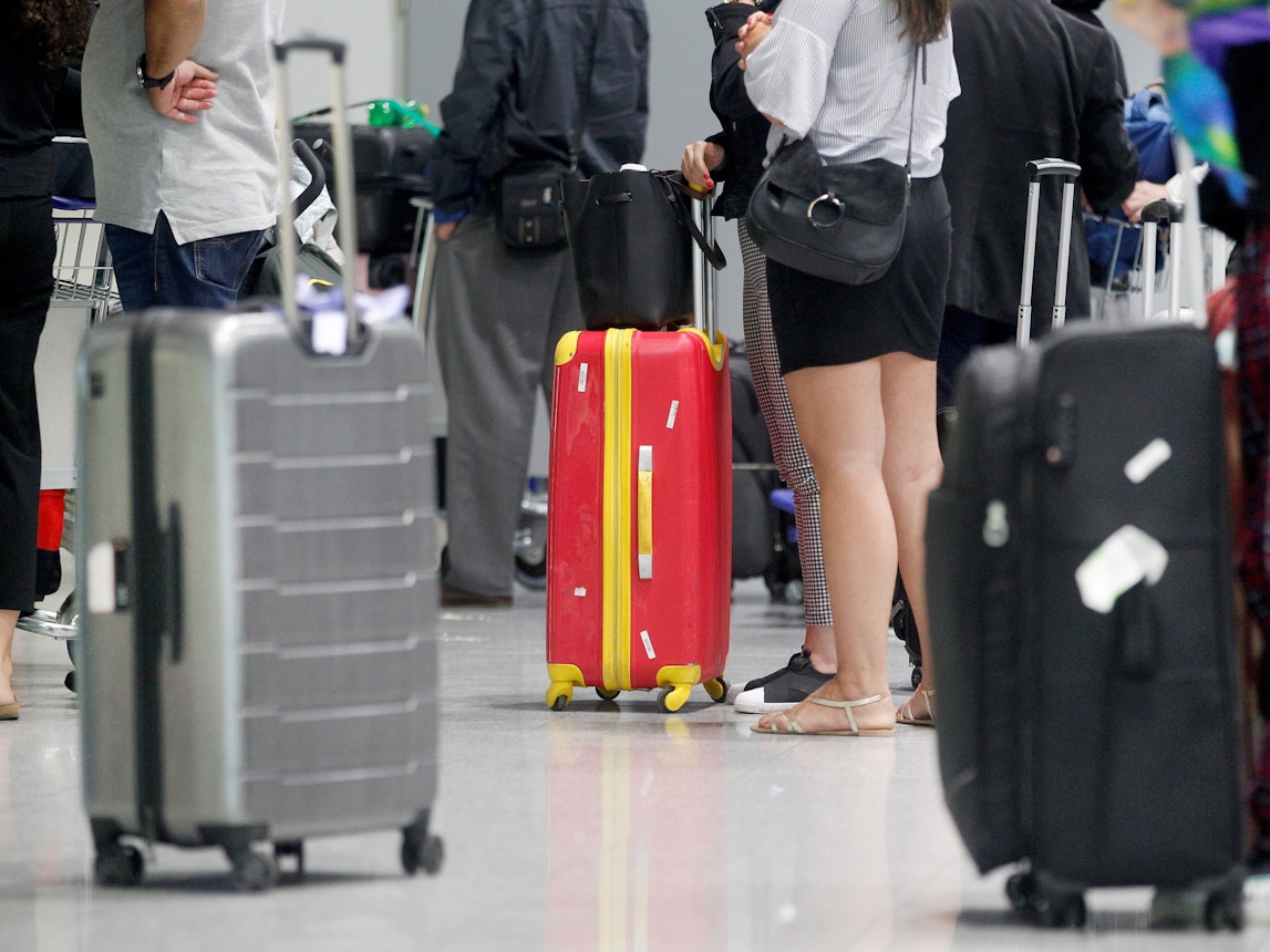 Fluggäste warten am Düsseldorfer Flughafen vor einem Check-In-Schalter auf ihre Abfertigung.