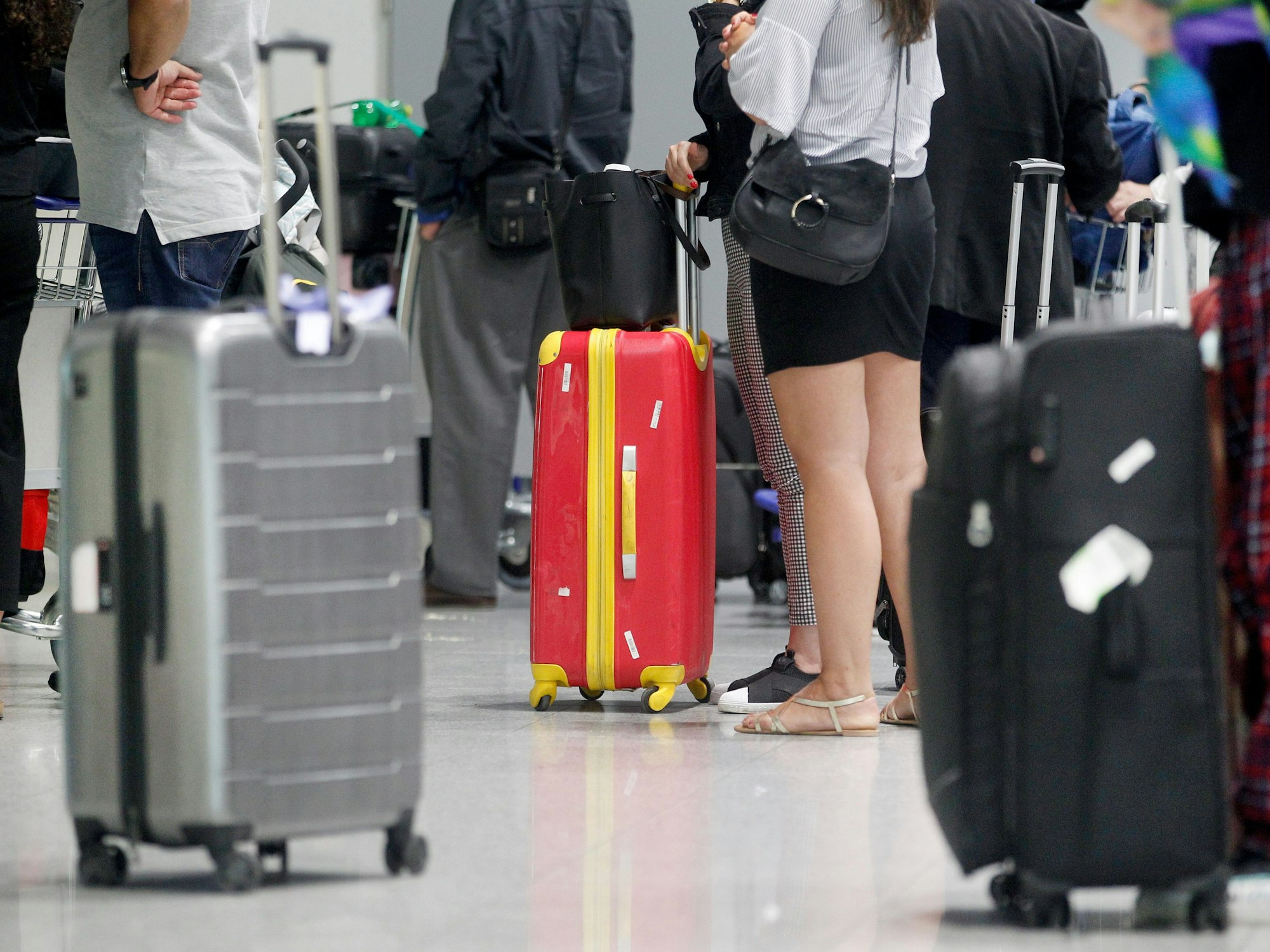 Fluggäste warten am Düsseldorfer Flughafen vor einem Check-In-Schalter auf ihre Abfertigung.