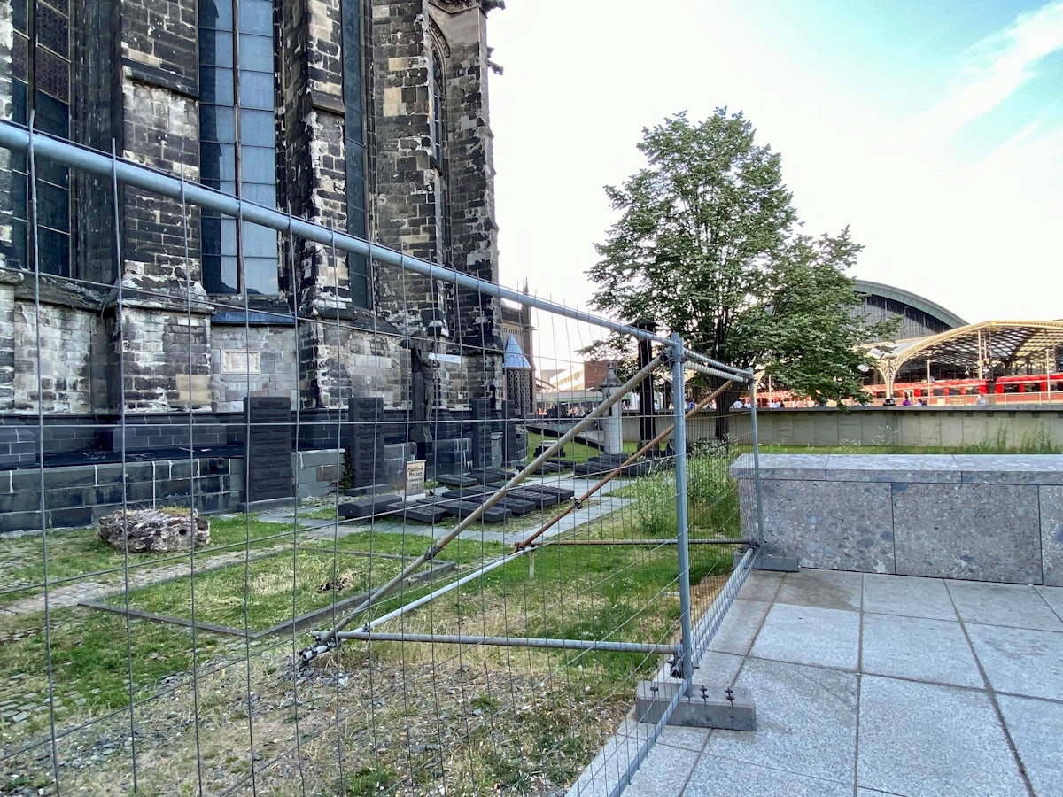 Ein Bauzaun umschließt den Domherrenfriedhof hinter dem Kölner Dom.