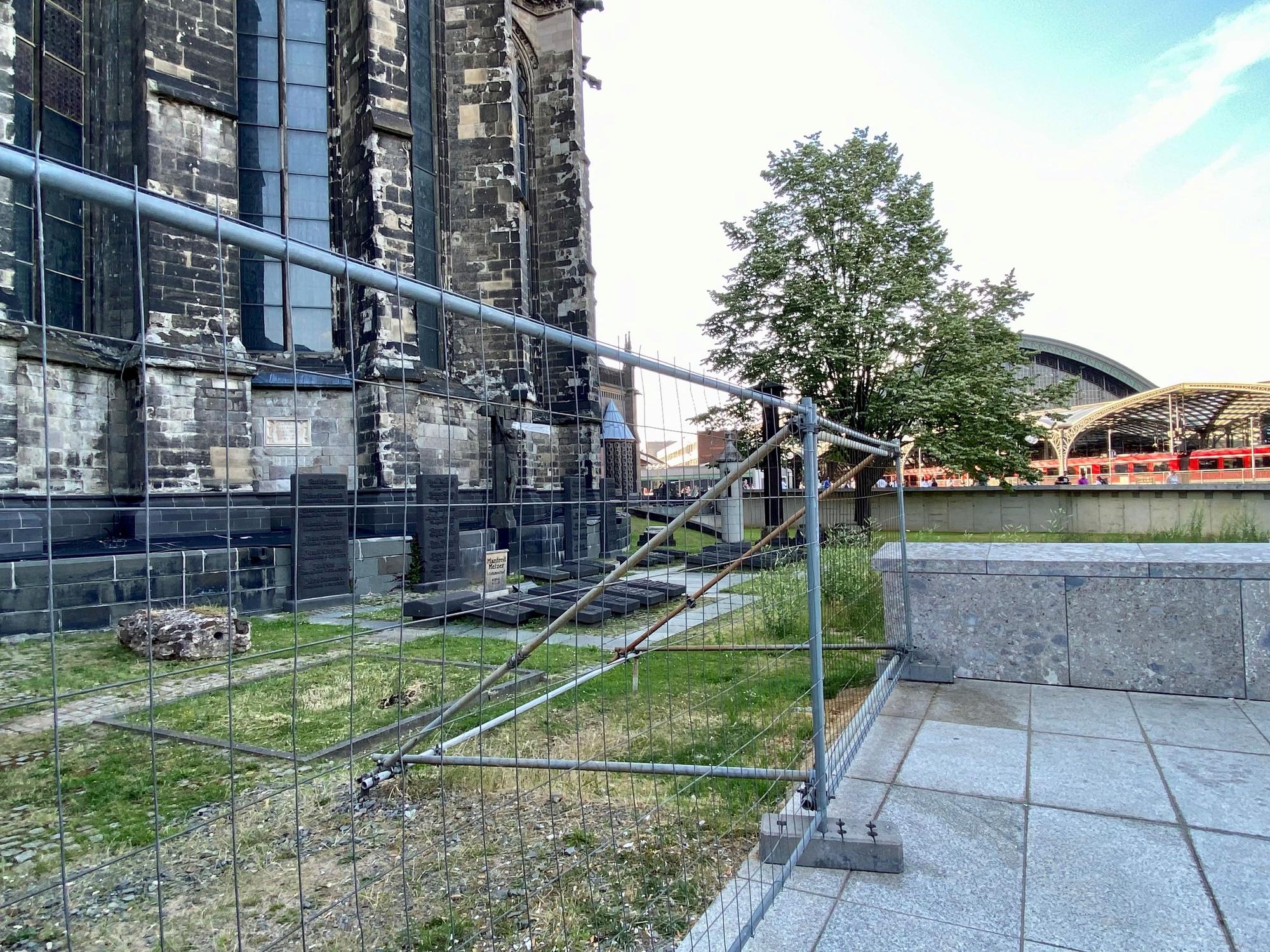 Ein Bauzaun umschließt den Domherrenfriedhof hinter dem Kölner Dom.
