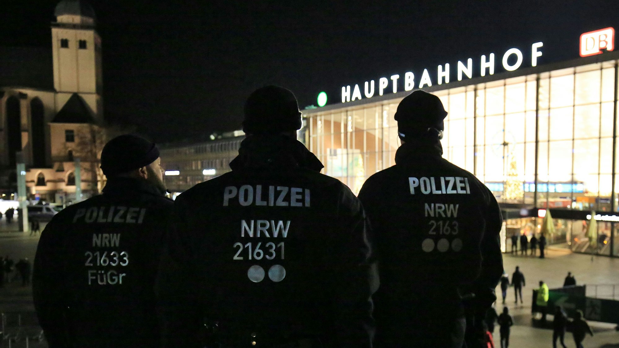 Drei Polizisten stehen in Uniform am 31. Dezember 2016 in Köln (Nordrhein-Westfalen) vor dem Hauptbahnhof.
