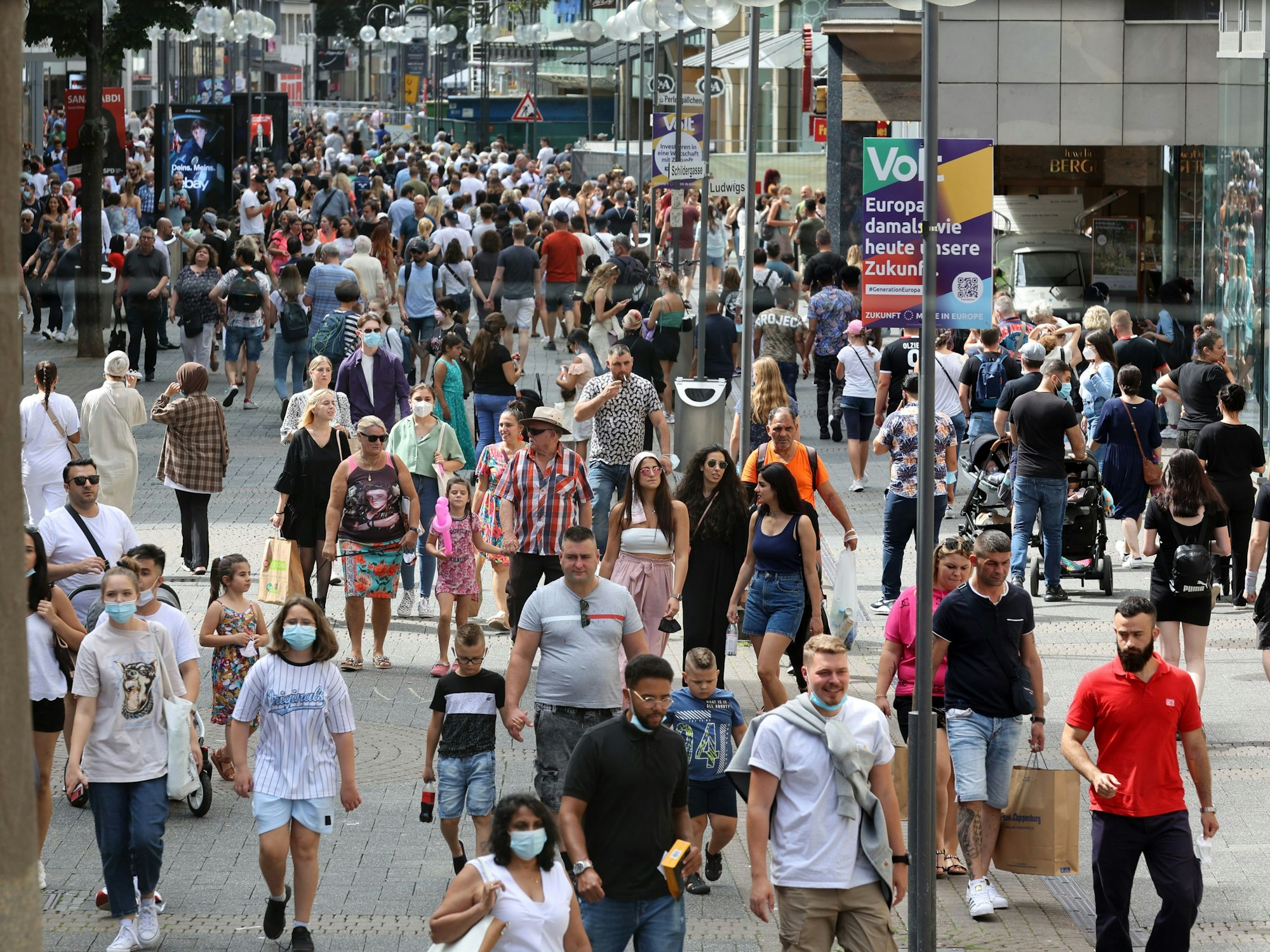Menschen gehen über die volle Schildergasse in Köln.