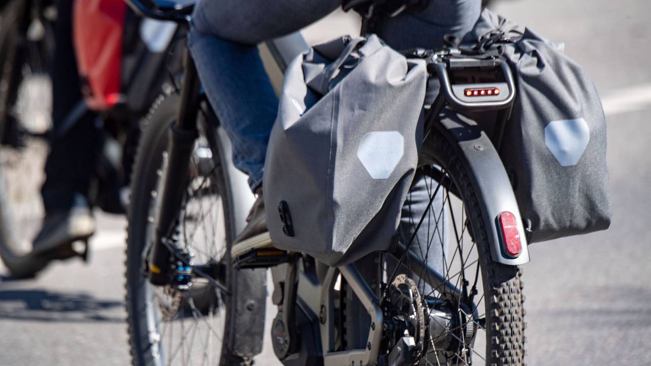 Touristen fahren mit Elektrorädern über eine Straße.