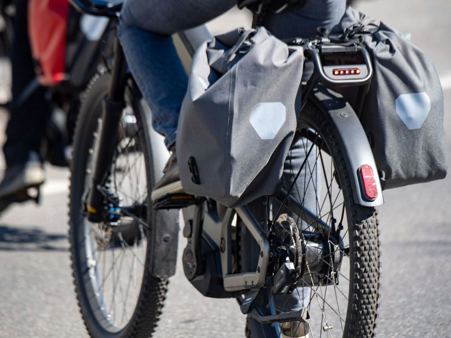 Touristen fahren mit Elektrorädern über eine Straße.