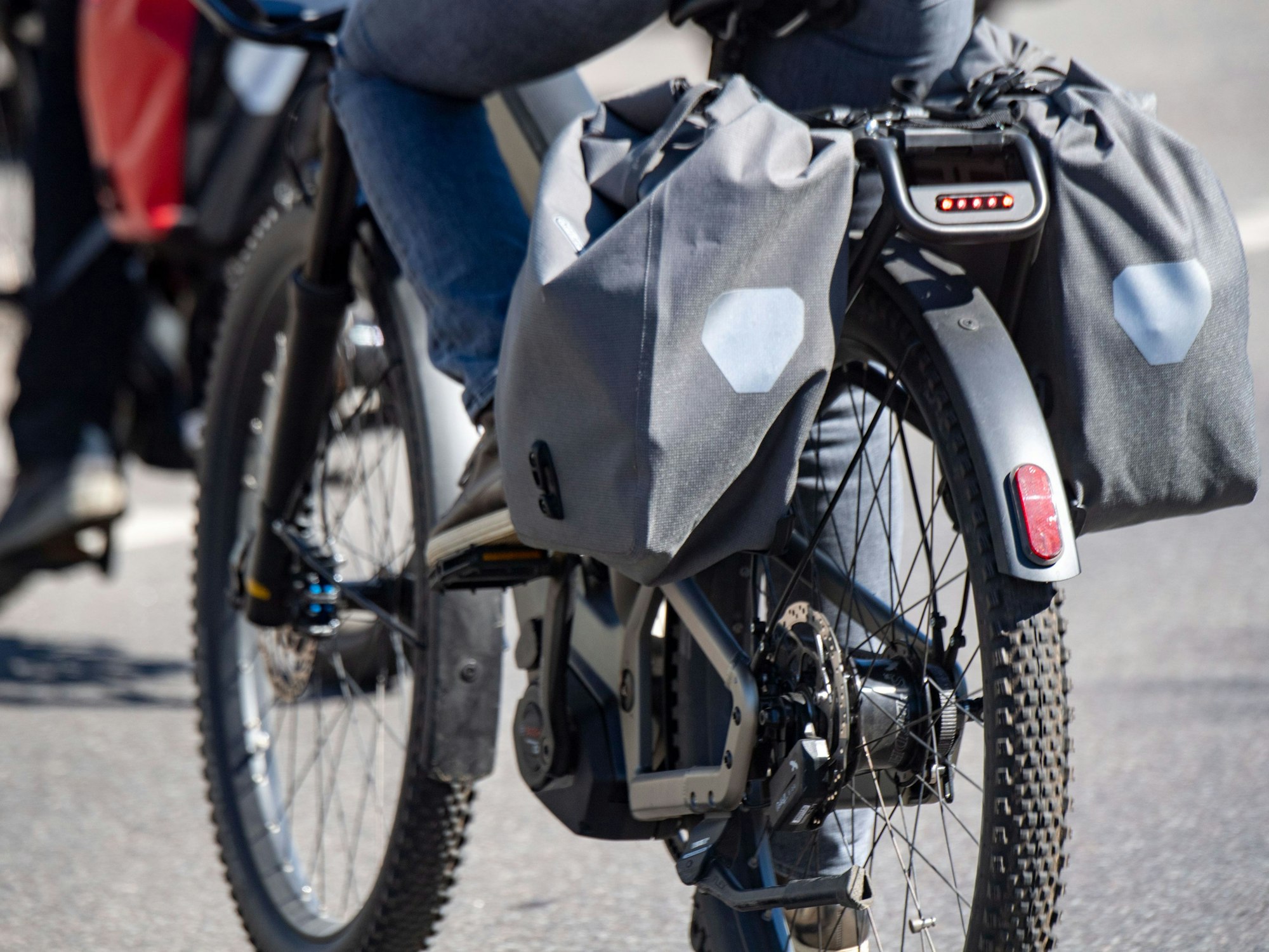 Touristen fahren mit Elektrorädern über eine Straße.