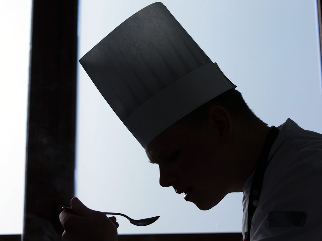 Ein Koch probiert ein Gericht.