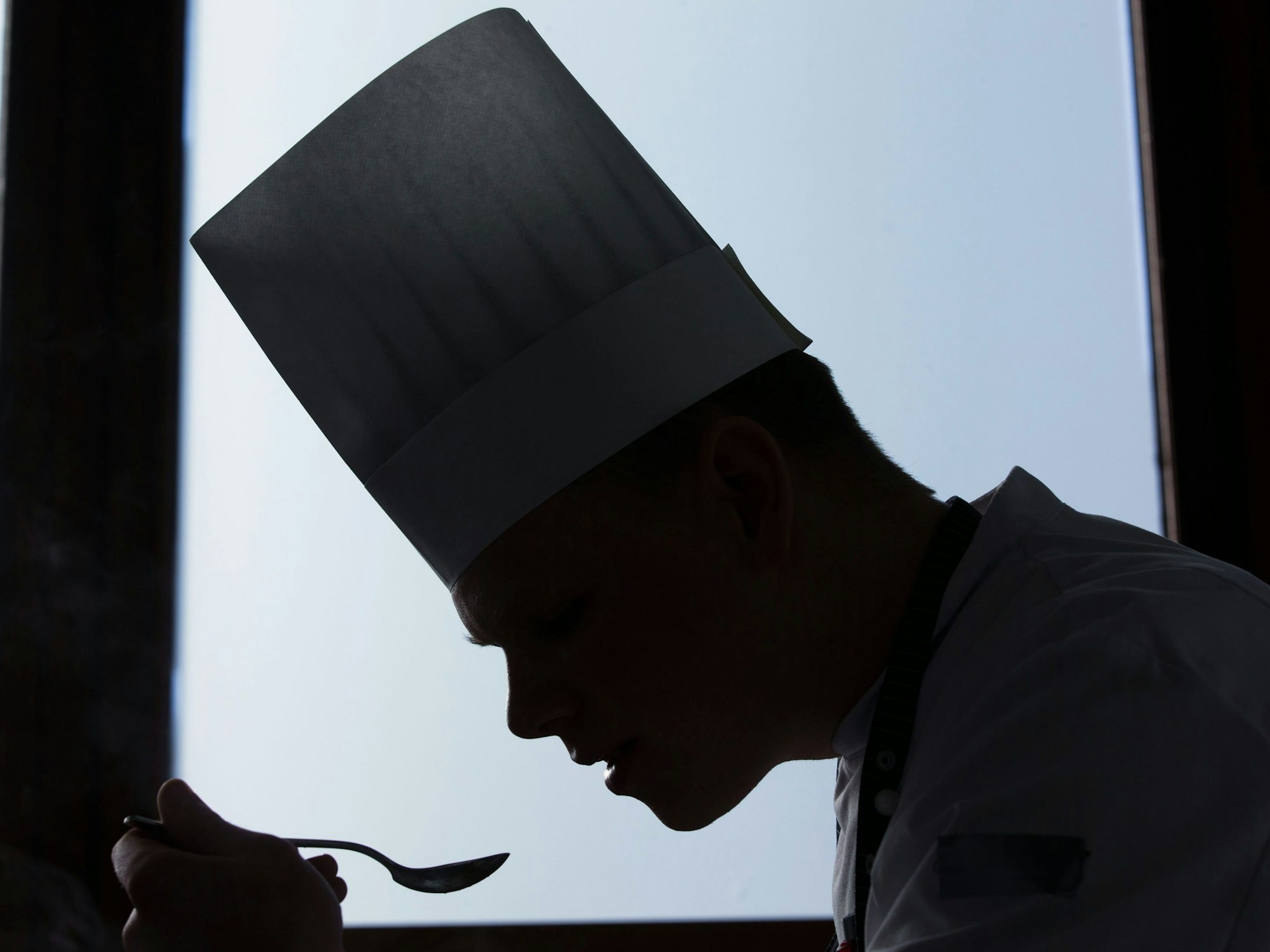 Ein Koch probiert ein Gericht.