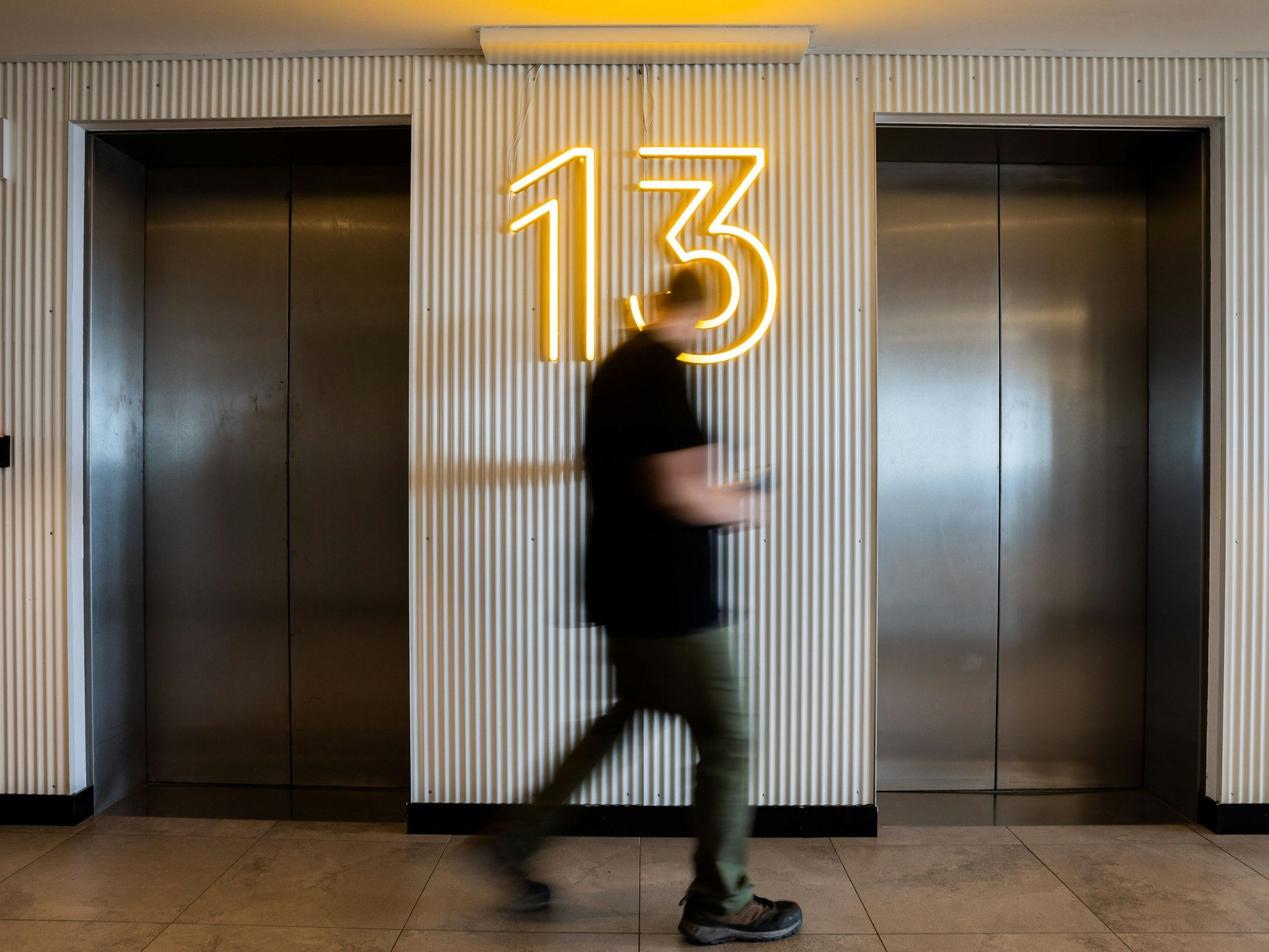 Ein Mann betätigt im 13. Stock einen Aufzug.