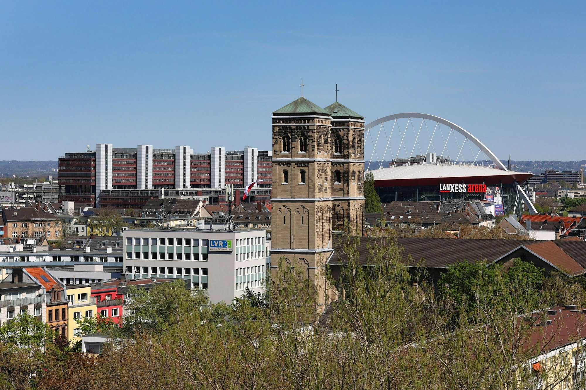 St. Heribert in Deutz mit der Köln Arena im Hintergrund.
