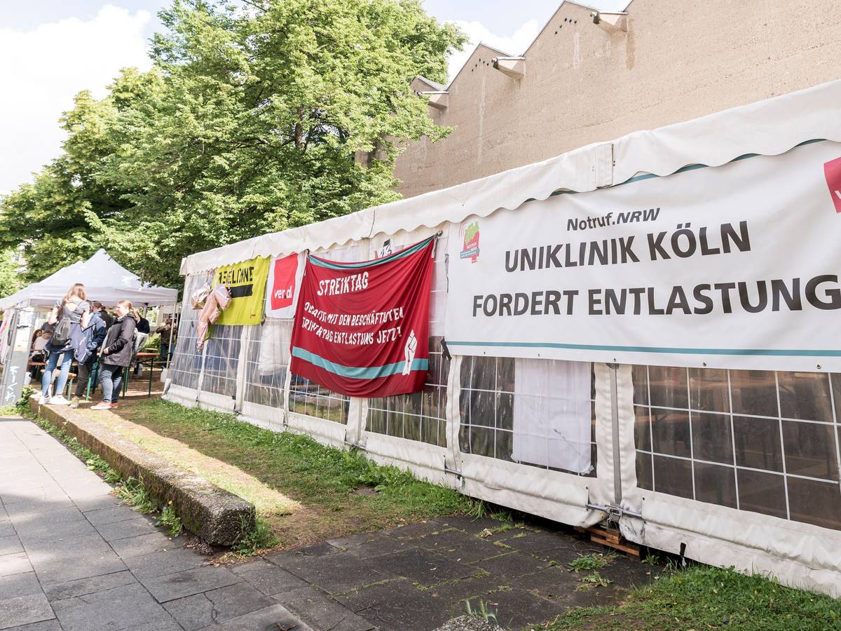 Streik an der Uniklinik in Köln, zu sehen ist ein Plakat auf einem Pavillon.