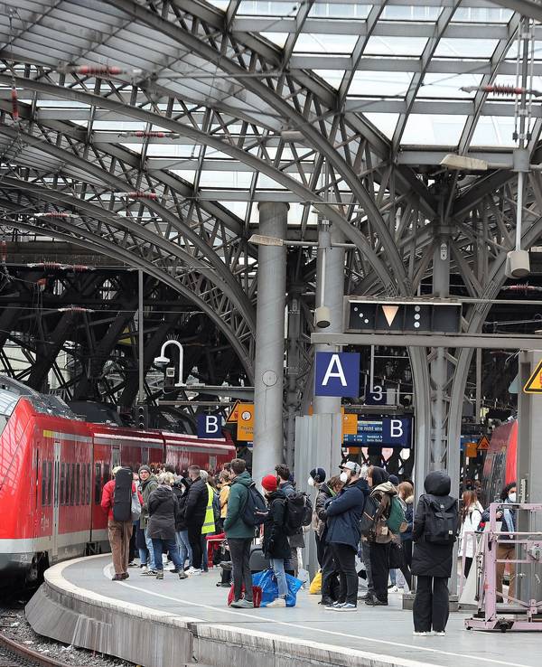 Zahlreiche Menschen warten auf einem Bahnsteig im Kölner Hauptbahnhof.