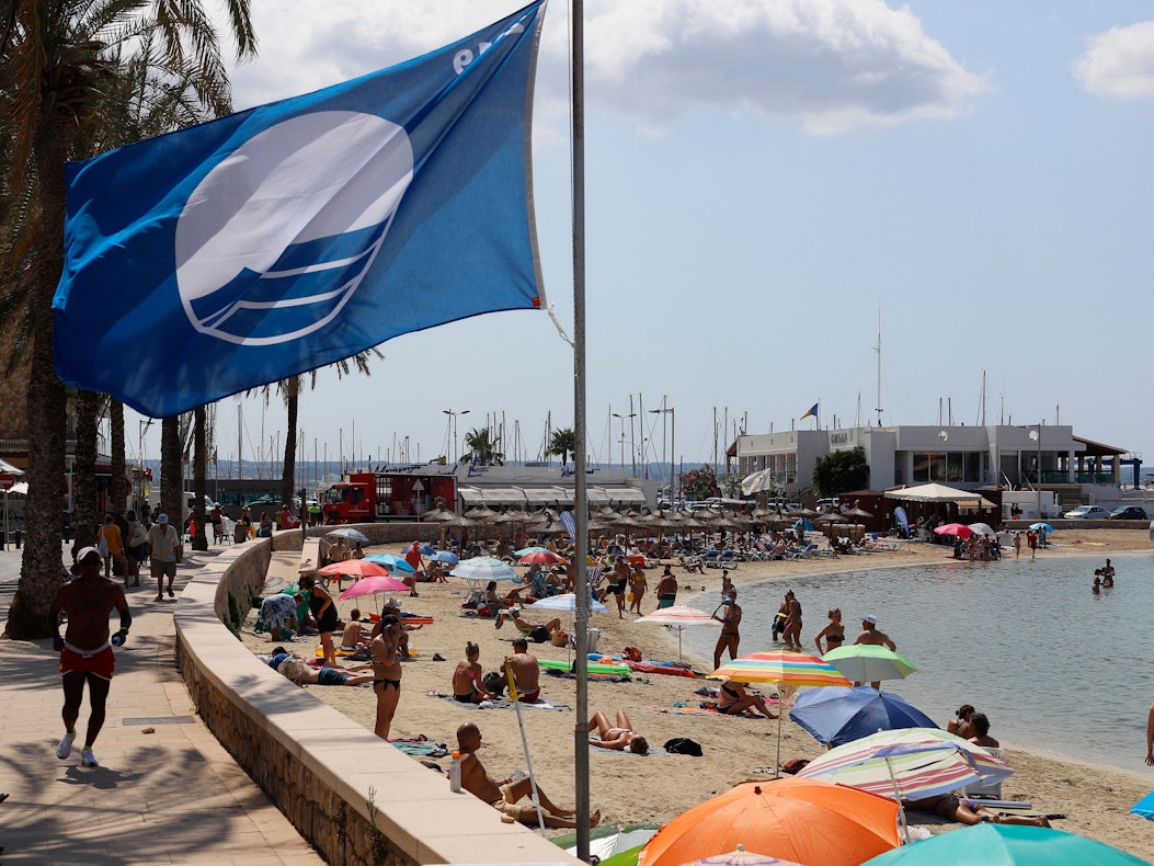 Eine blaue Flagge als Gütezeichen für „gute Wasserqualität“ weht am Strand der Bucht Cala Estancia im Wind (aufgenommen 2019).