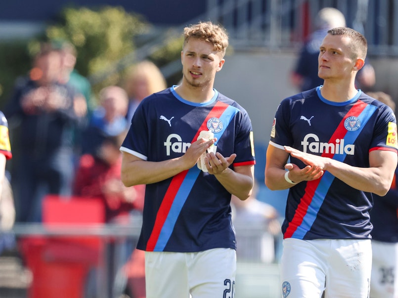 Fabian Resse (r.) und Jann-Fiete Arp gehen im Vorjahres-Trikot von Holstein Kiel im Zweitliga-Spiel gegen den FC Heidenheim über den Rasen