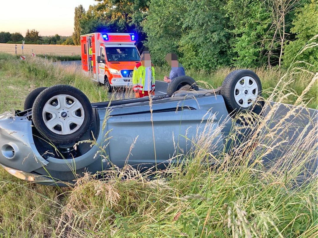 Auto liegt an einem Feld auf dem Dach.
