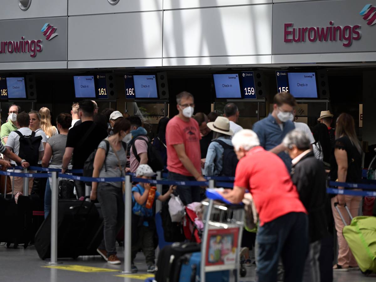 Zahlreiche Passagiere stehen an den Eurowings-Schaltern im Flughafen Düsseldorf.
