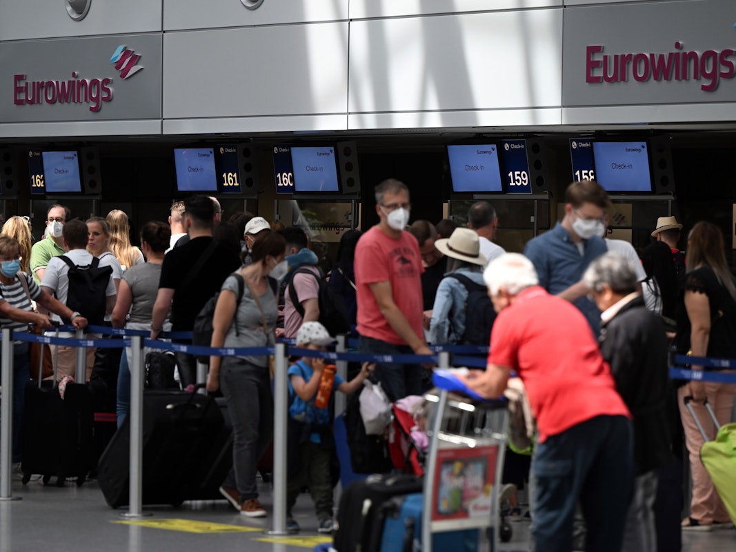 Zahlreiche Passagiere stehen an den Eurowings-Schaltern im Flughafen Düsseldorf.