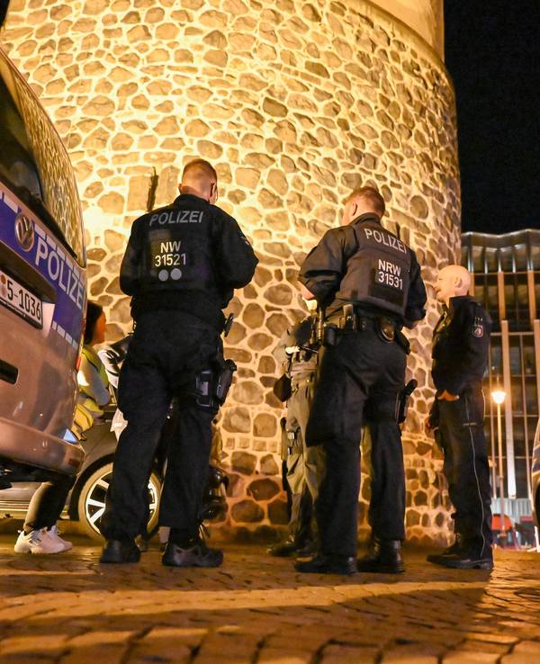 Einsatzkräfte der Polizei besprechen einen Einsatz in der Nacht.