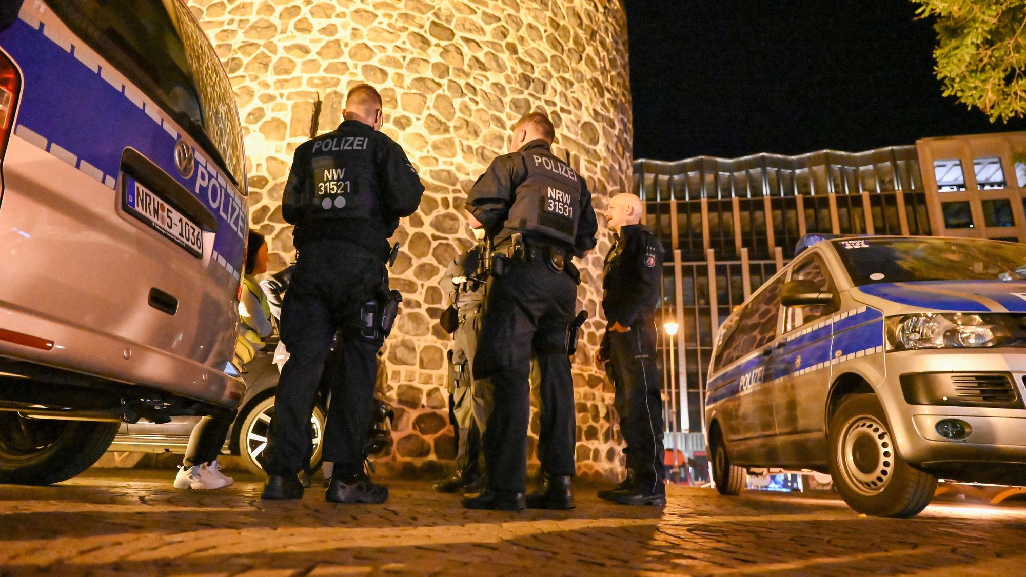 Einsatzkräfte der Polizei besprechen einen Einsatz in der Nacht.