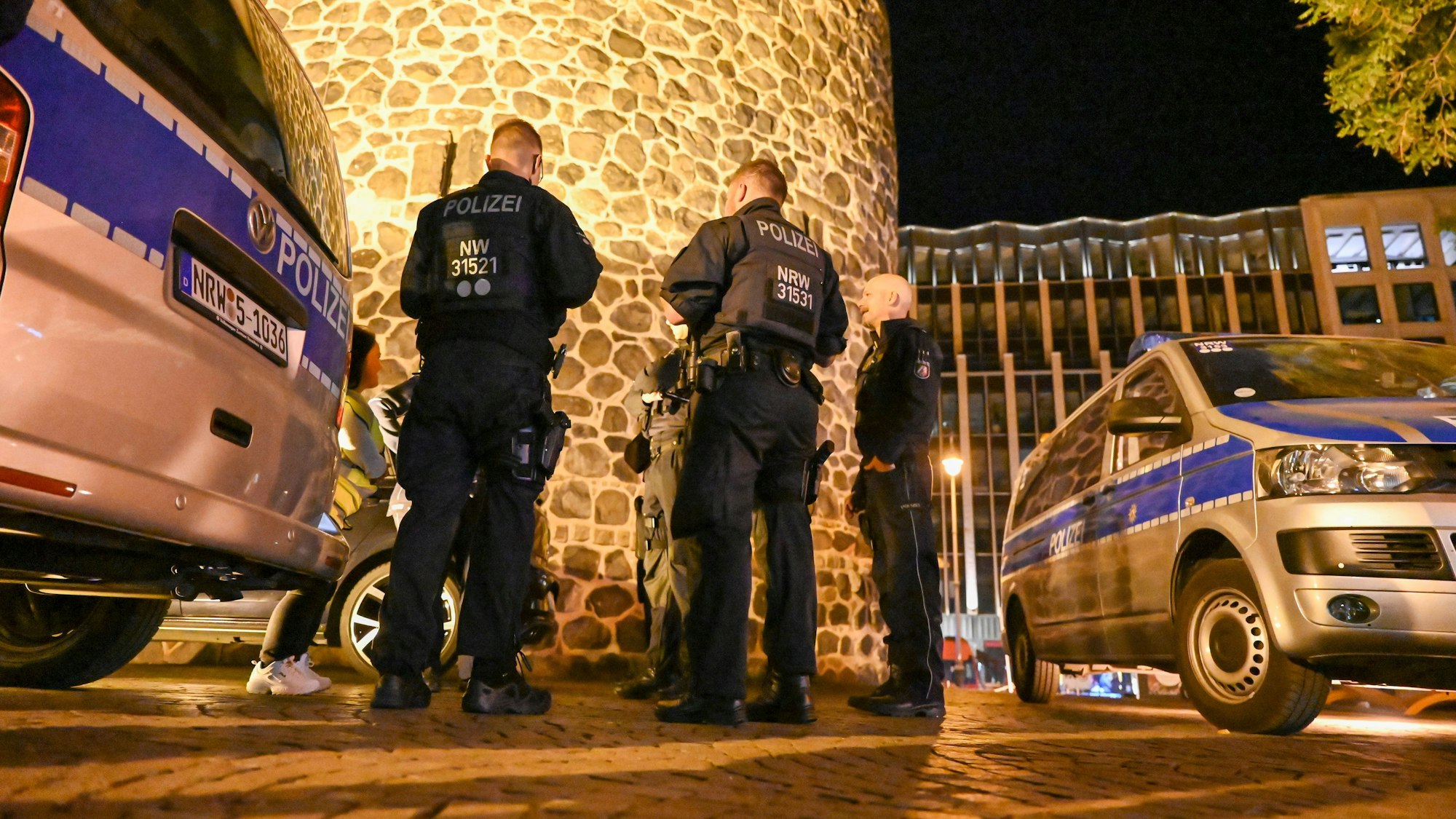 Einsatzkräfte der Polizei besprechen einen Einsatz in der Nacht.