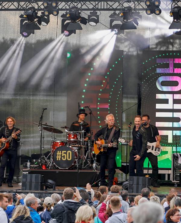 Die Höhner geben auf einer Bühne vor vielen Fans ein Konzert.