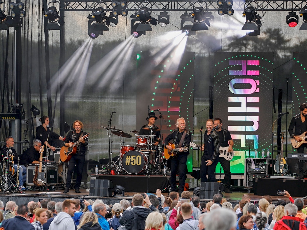 Die Höhner geben auf einer Bühne vor vielen Fans ein Konzert.