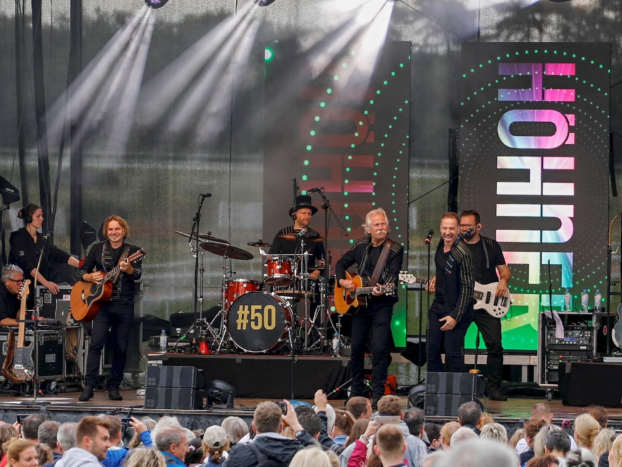 Die Höhner geben auf einer Bühne vor vielen Fans ein Konzert.
